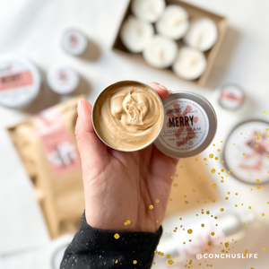 Open tin of CONCHUS MERRY Light Cream Shimmer held above festive CONCHUS packaging.