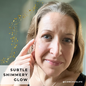 Person using CONCHUS MERRY Light Cream Shimmer on face for soft golden radiance.
