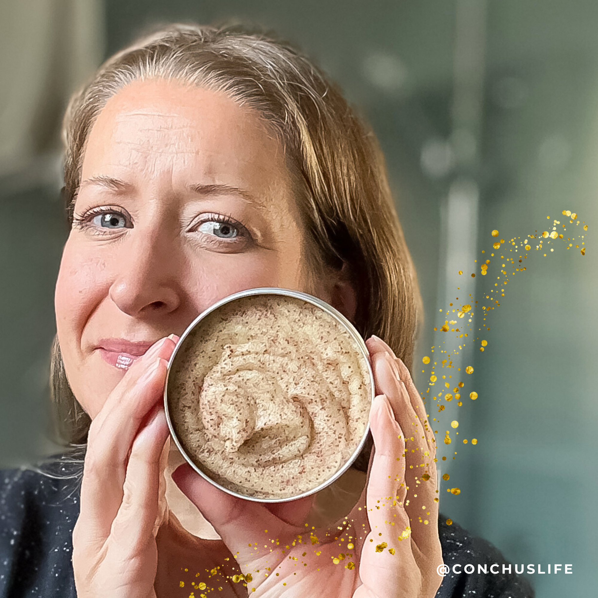 Person holding open tin of CONCHUS MERRY Sugar Scrub showing creamy festive exfoliating texture