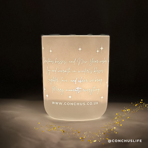Lit CONCHUS MERRY Botanical Candle displaying illuminated festive poem on vessel